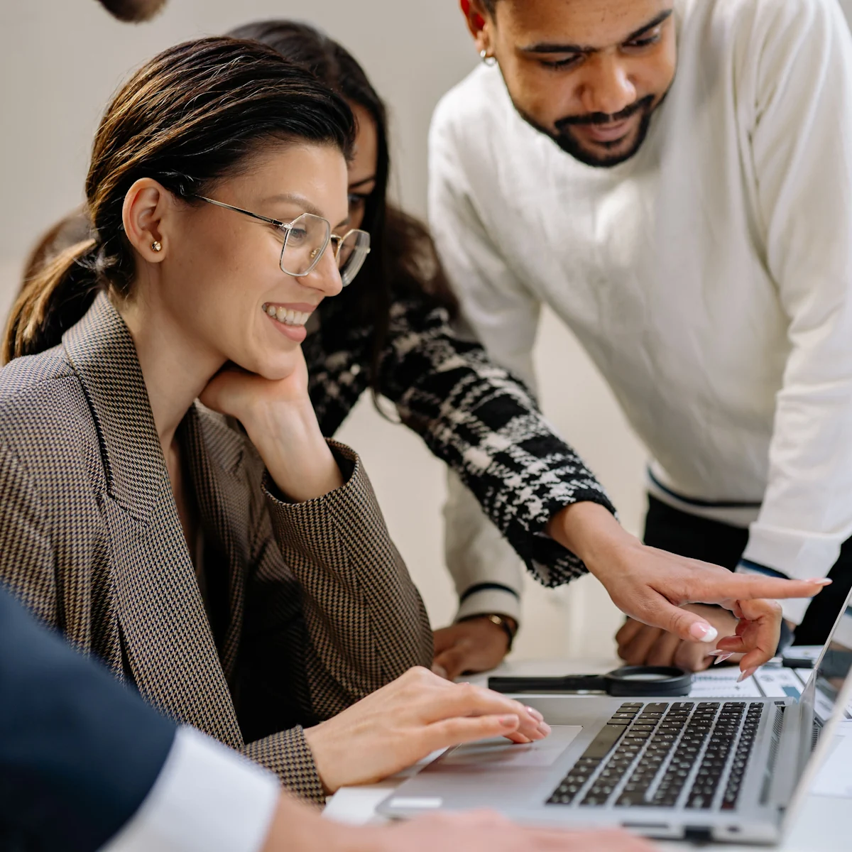 Two colleagues talking across a desk in a bright office