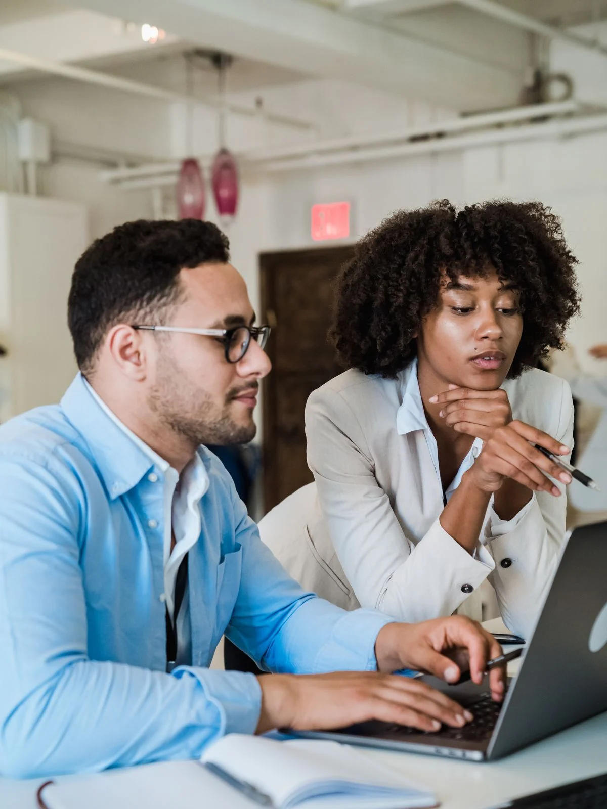 Two colleagues going through the week's work together on a laptop