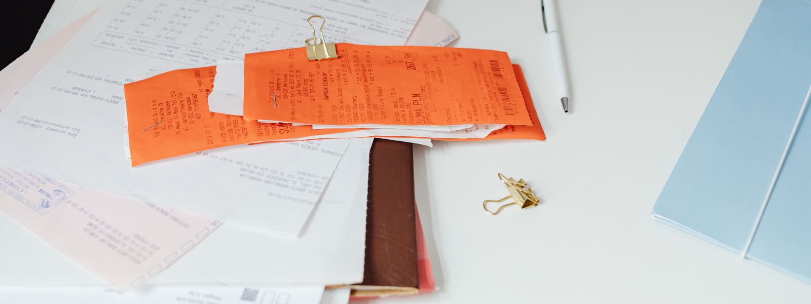 Printed receipts, invoice documents and office stationery laid out neatly on a desk
