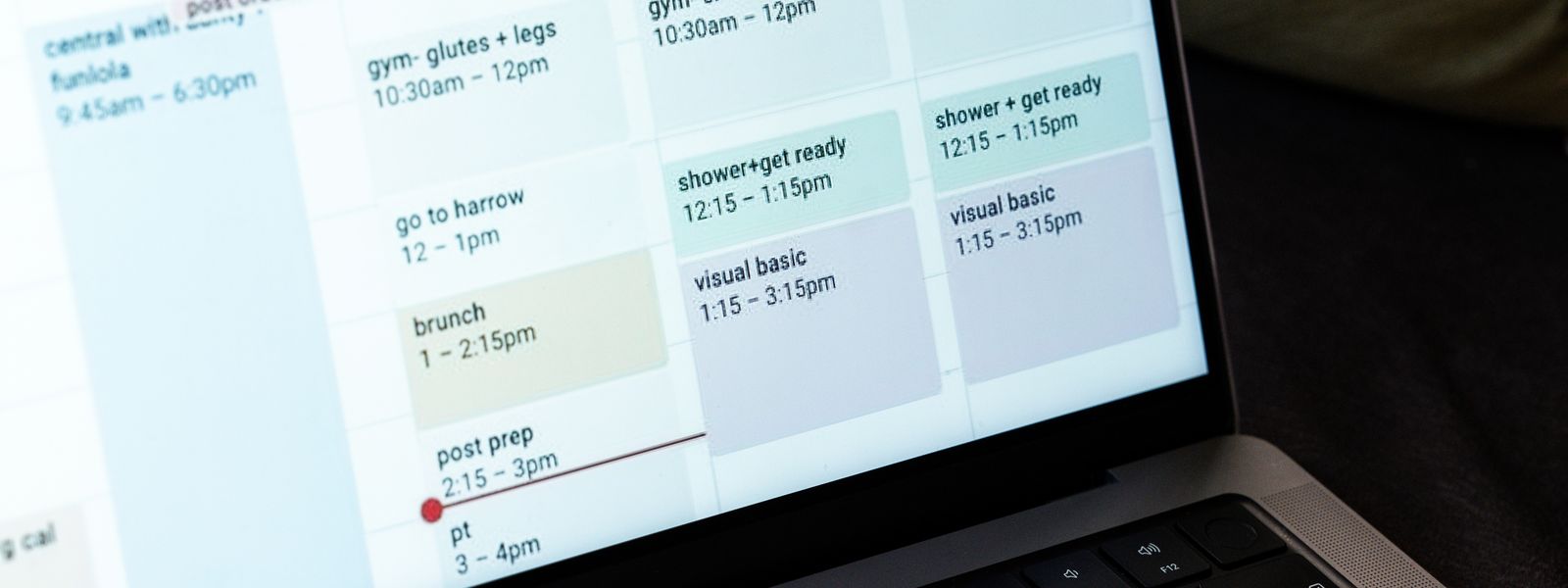 Laptop screen showing a colour-coded weekly calendar full of timed events